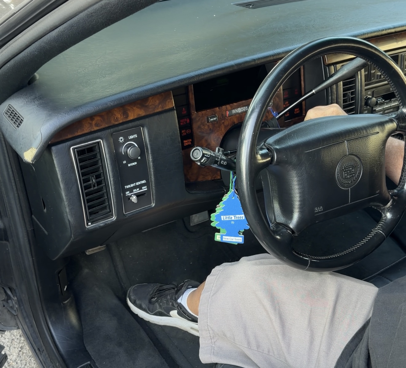 Interior of the 1994 Cadillac Fleetwood showing the steering column, ignition cylinder area, and classic wood-grain dash with warning lights visible