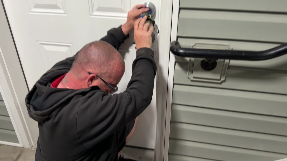 Precision Lock & Key locksmith working on a Kwikset SmartKey deadbolt during a nighttime apartment lockout in Spokane