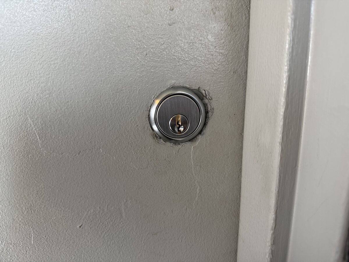 Brand new brushed nickel deadbolt cylinder installed on commercial door after emergency lockout service