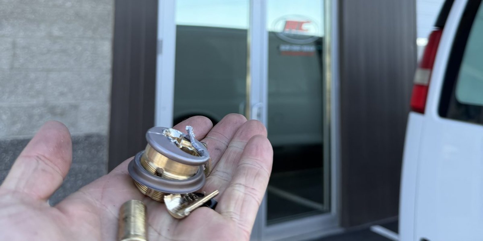 Greg holding destroyed mortise cylinder and broken brass pieces at RC Roofing Specialists in Liberty Lake WA